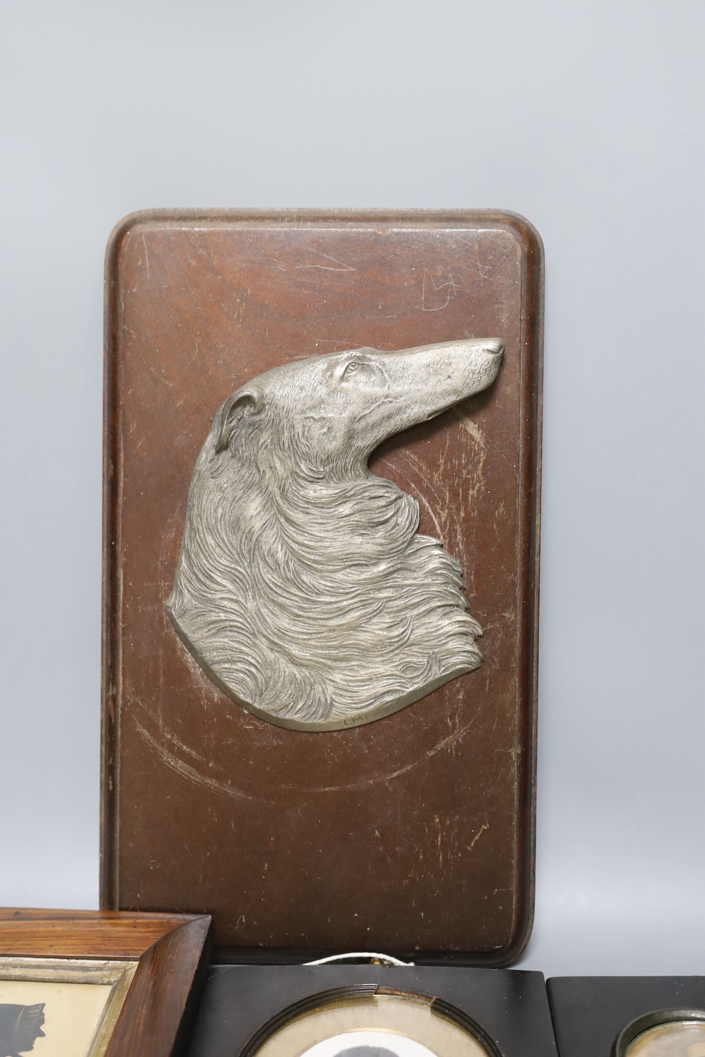Two Victorian silhouette portraits, a printed monochrome bust, all framed together, with an early 20th century German relief of a borzoi, 33 x 19cm